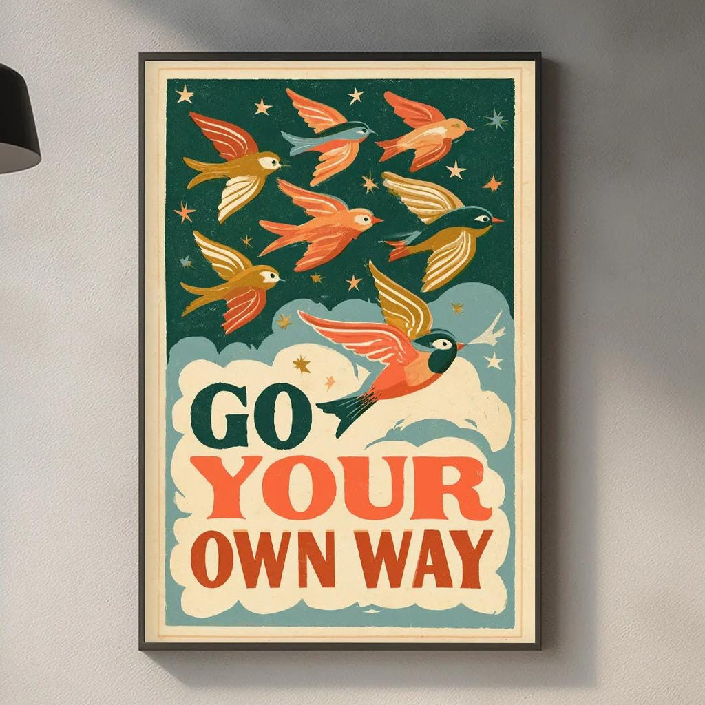 a framed poster with a bird illustration and the text "Go Your Own Way" hanging on a wall above a kitchen counter.
