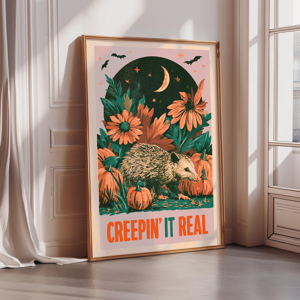 a poster with a whimsical illustration of a hedgehog surrounded by flowers and pumpkins, with a crescent moon and stars in the background. The poster has a bold, orange and green color scheme, and the text "CREEPIN' IT REAL" is prominently displayed.