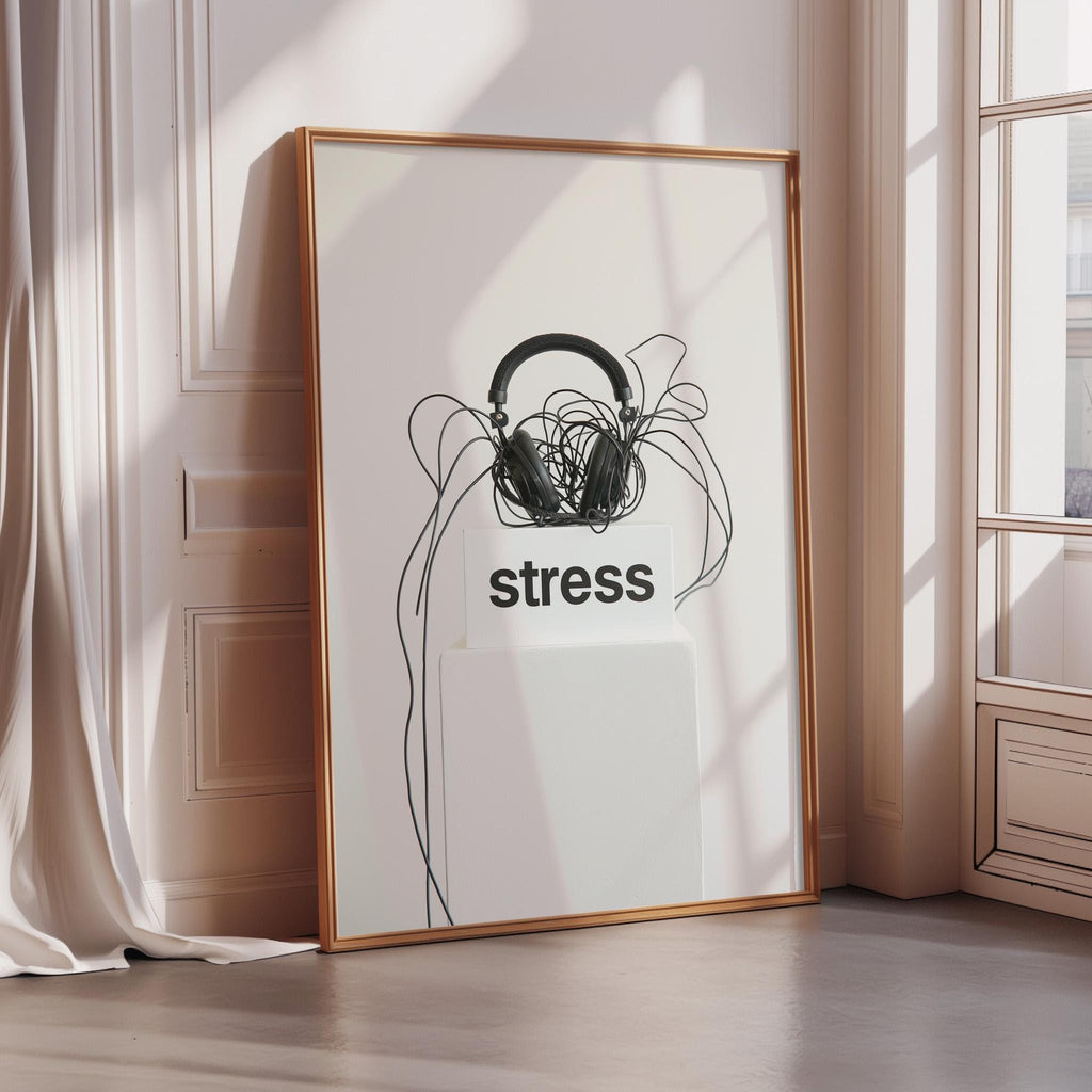 a framed poster with the word "stress" written on it, along with a pair of headphones and tangled wires.