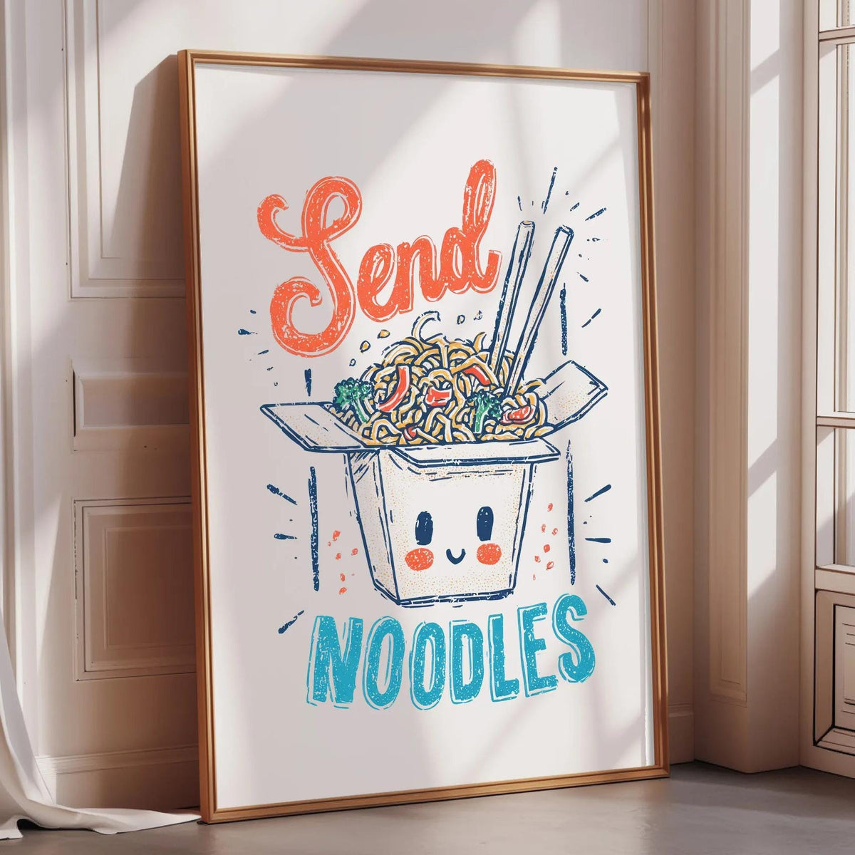 A framed poster with a cartoon noodle box and the text "Send Noodles" on it, placed on a wooden floor against a white wall.