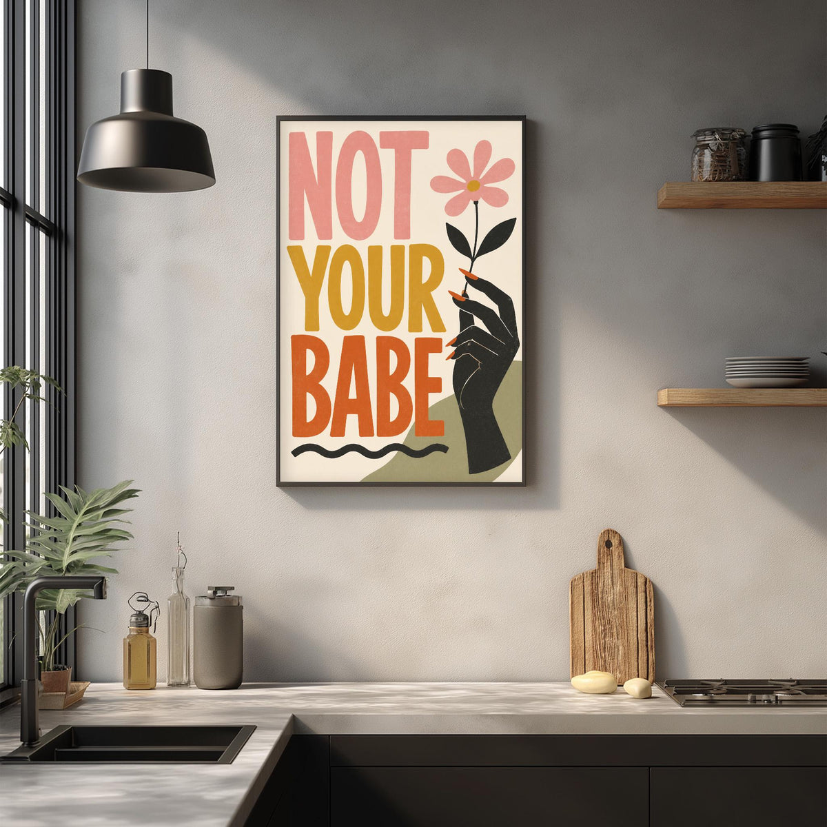 a kitchen counter with a framed poster that reads "NOT YOUR BABE" above it. The poster has a black hand holding a flower, and the text is in bold, colorful letters.