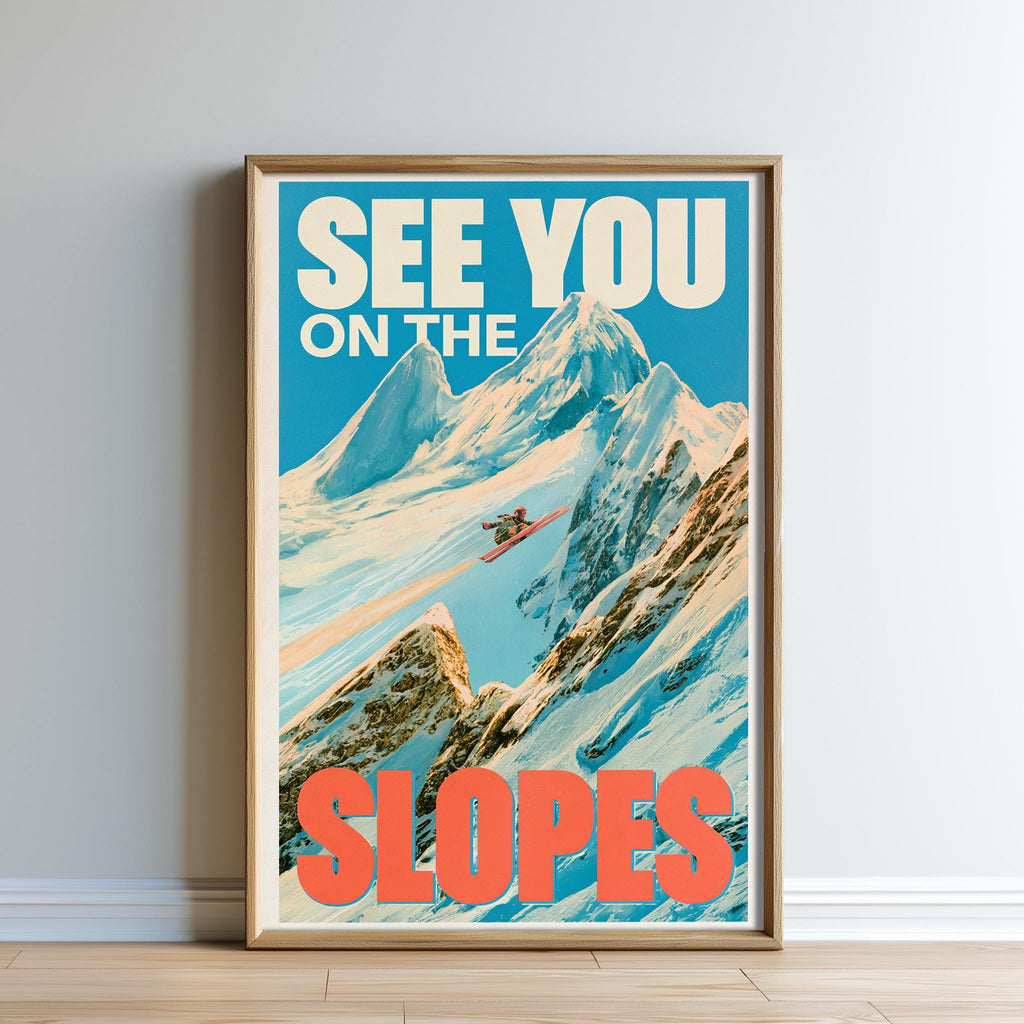 A framed poster with a mountain landscape and a skier in the background, along with the text "SEE YOU ON THE SLOPES" prominently displayed.