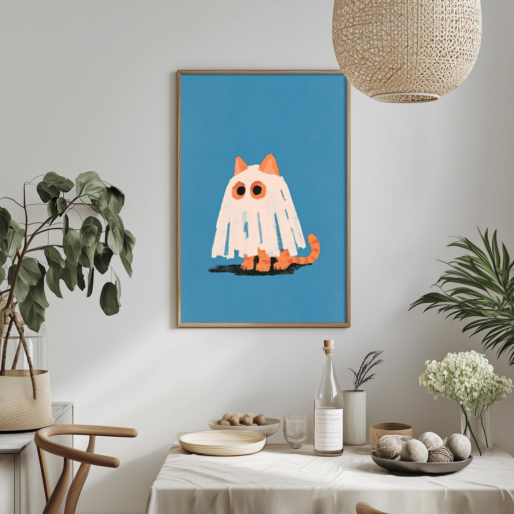 a framed illustration of a ghost cat with a blue background and orange accents, hanging on a wall above a dining table with various decorative items and plants.
