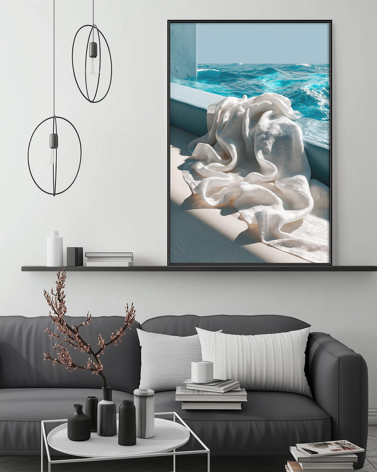 a modern living room with a gray sofa, a coffee table, and a large framed picture of a white towel hanging on a wall.