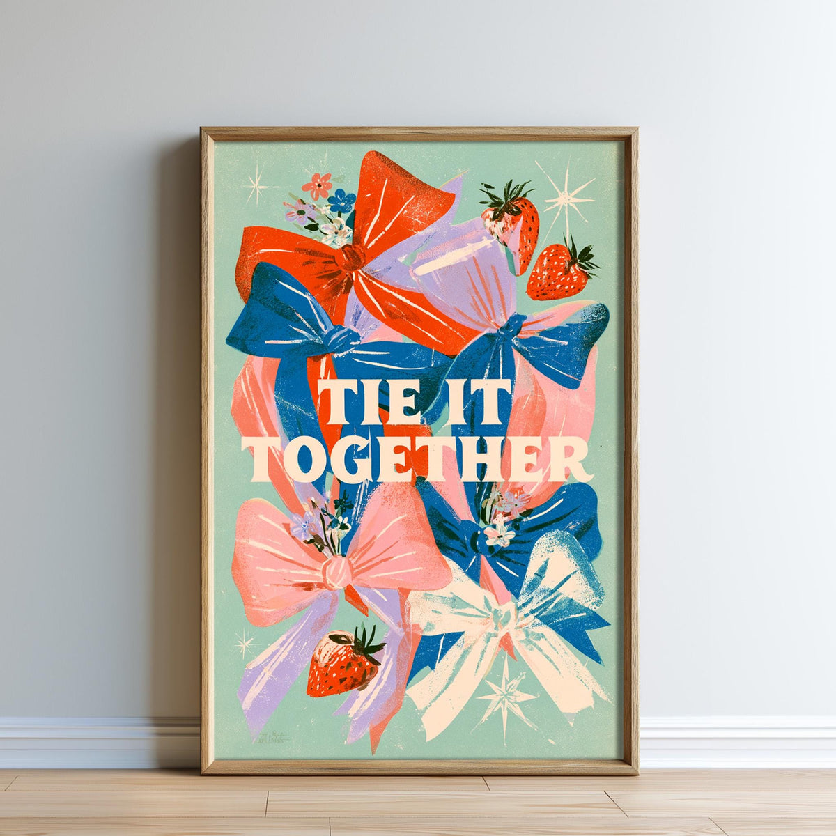 The image is a framed poster with a colorful illustration of bows and strawberries. The text on the poster says "tie it together".