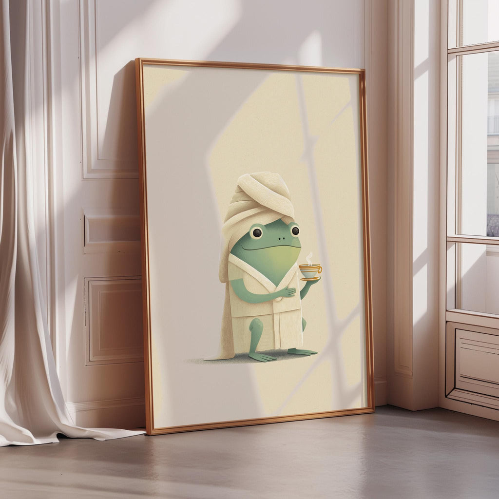 A framed illustration of a frog wearing a bathrobe and holding a cup, set against a light background.