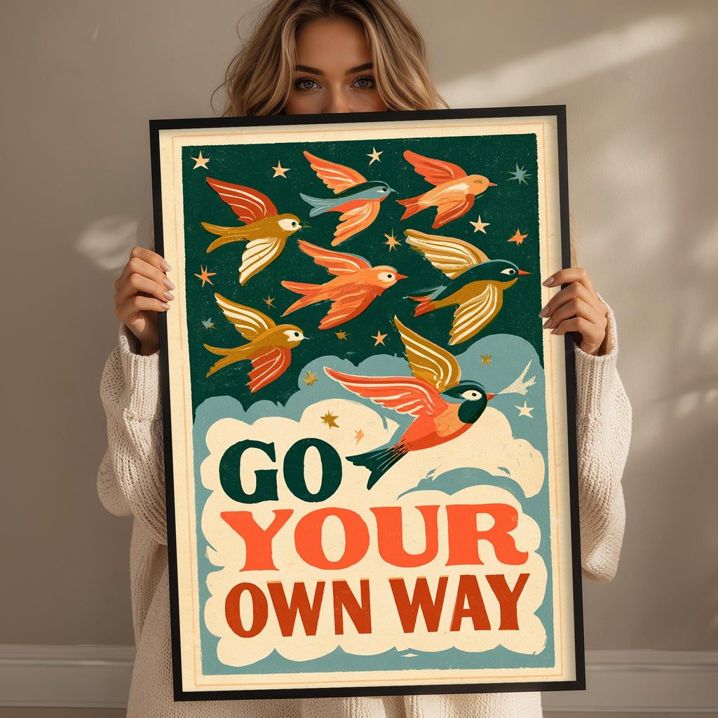 A woman holding a framed poster with a colorful illustration of birds flying against a starry sky background.