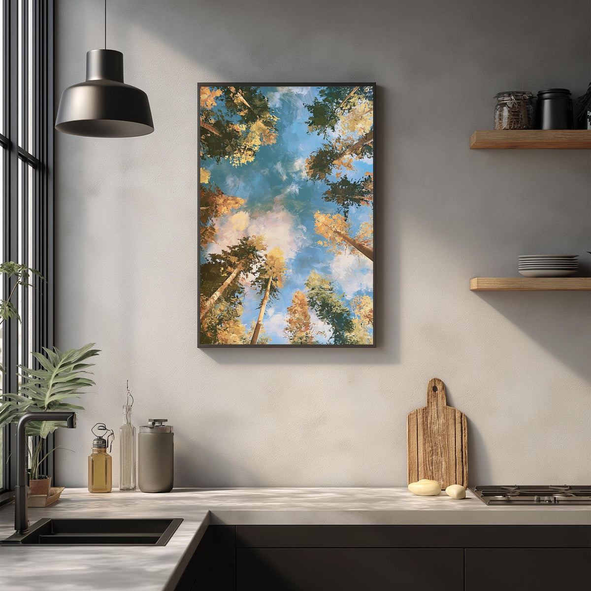 a kitchen counter with a framed picture of a forest scene hanging above it. The kitchen counter has various items on it, including a cutting board, a bottle, and a vase. The overall scene is serene and natural, with the forest scene providing a calming atmosphere.