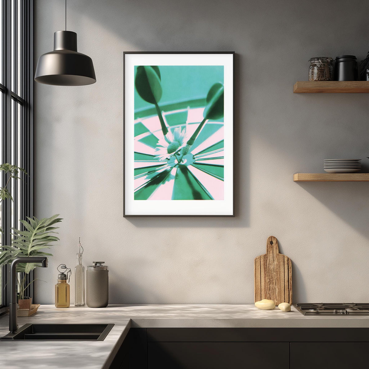 a kitchen counter with various items, including a framed picture, a cutting board, and a plant.