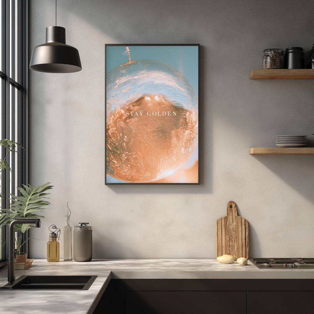 a kitchen counter with a framed poster of a globe hanging above it, along with various kitchen items such as a cutting board, a soap dispenser, and a plant.