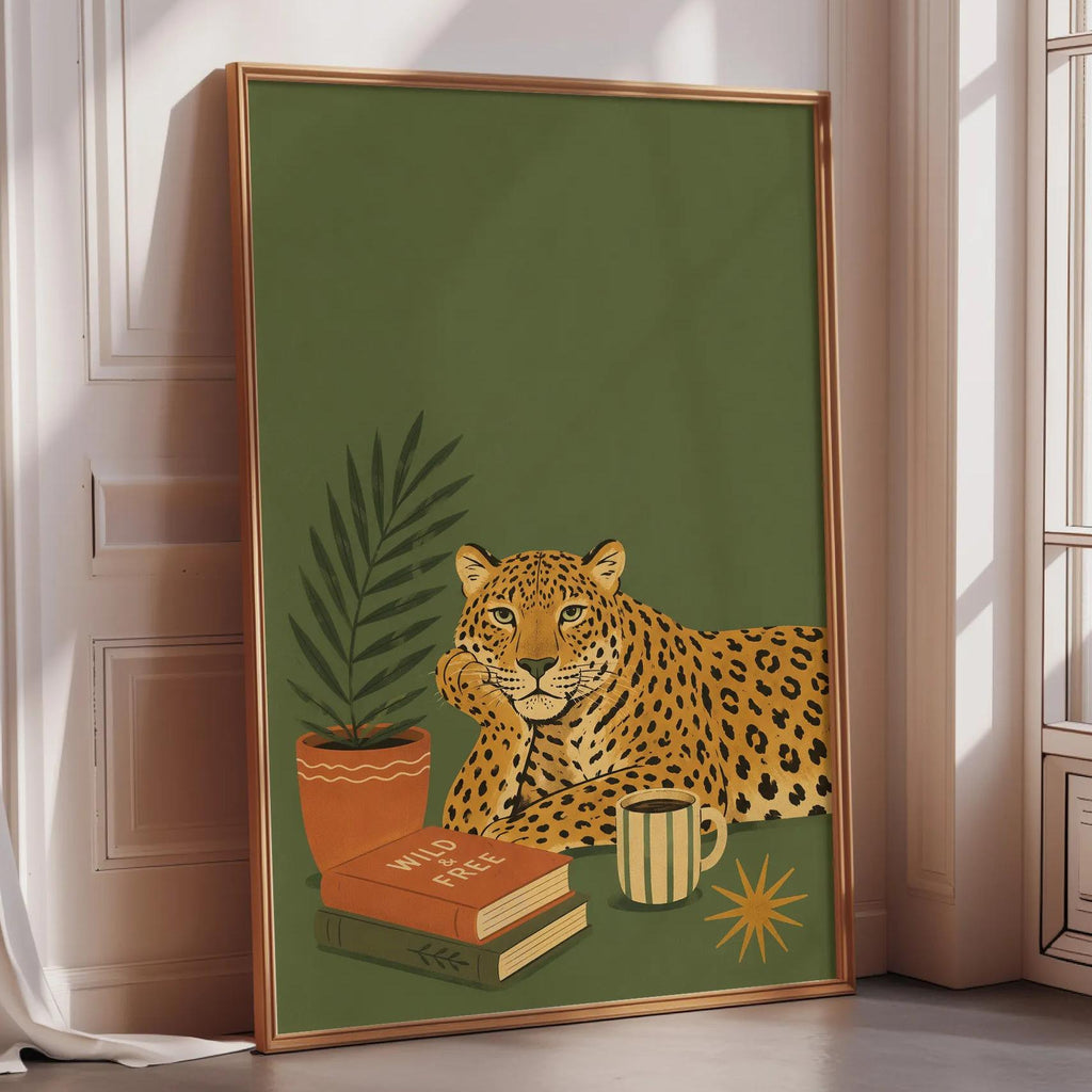 A framed poster depicting a leopard resting on a bookshelf with a cup of coffee and a plant, set against a green background.