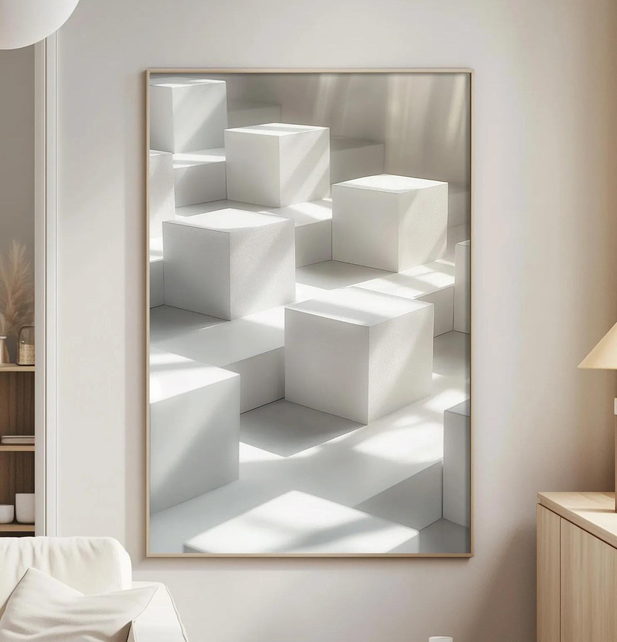 a minimalist living room with a large white cube-shaped artwork hanging on the wall, a white sofa, a wooden side table, and a lamp on a wooden cabinet.
