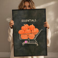 A woman holding a framed poster with a shopping cart filled with pumpkins.