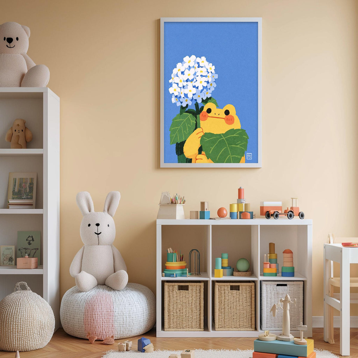 A child's bedroom with a white bookshelf, a stuffed rabbit, a framed illustration of a frog holding flowers, and a toy train on a shelf.