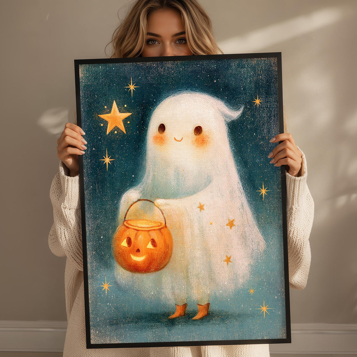 A woman holds up a framed painting depicting a ghost with a carved pumpkin in its hand, set against a starry night sky background.