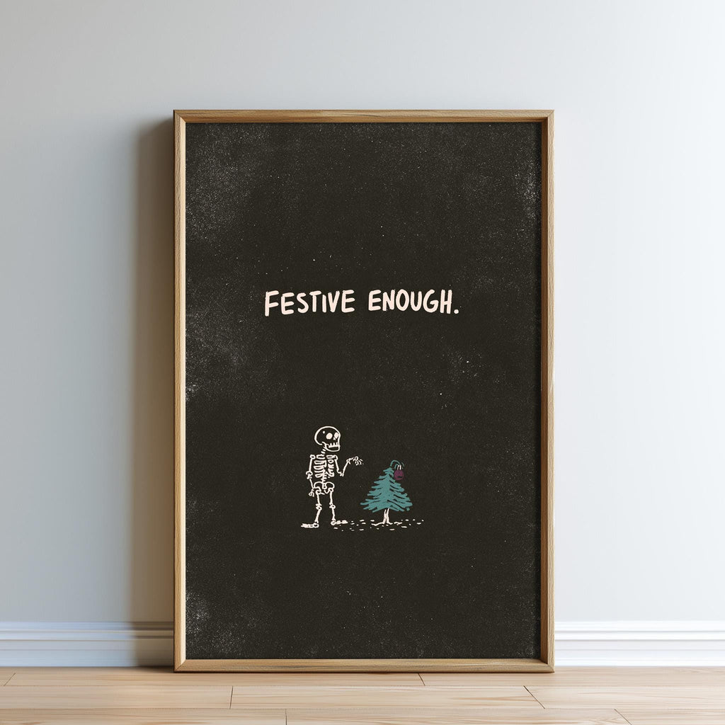 a skeleton standing next to a small Christmas tree, with the text "FESTIVE ENOUGH" written above the skeleton.