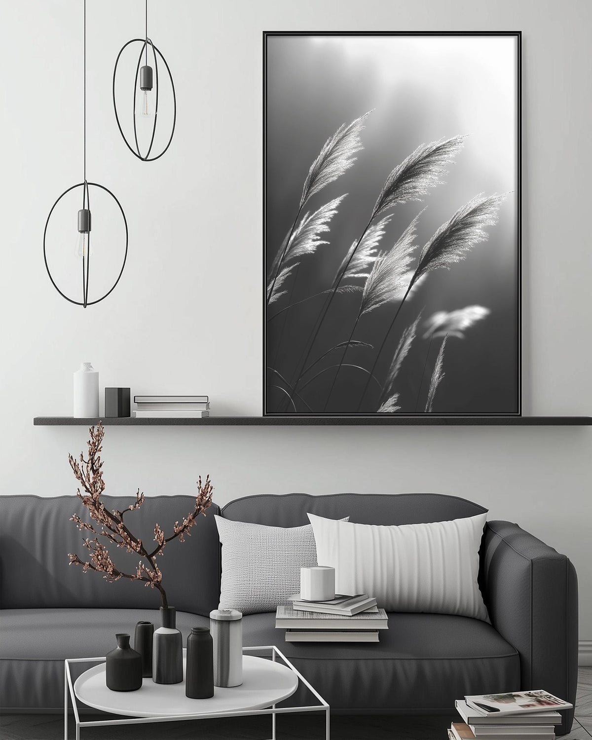 a modern living room with a gray sofa, a coffee table, and a large black and white photograph of tall grasses hanging on the wall.