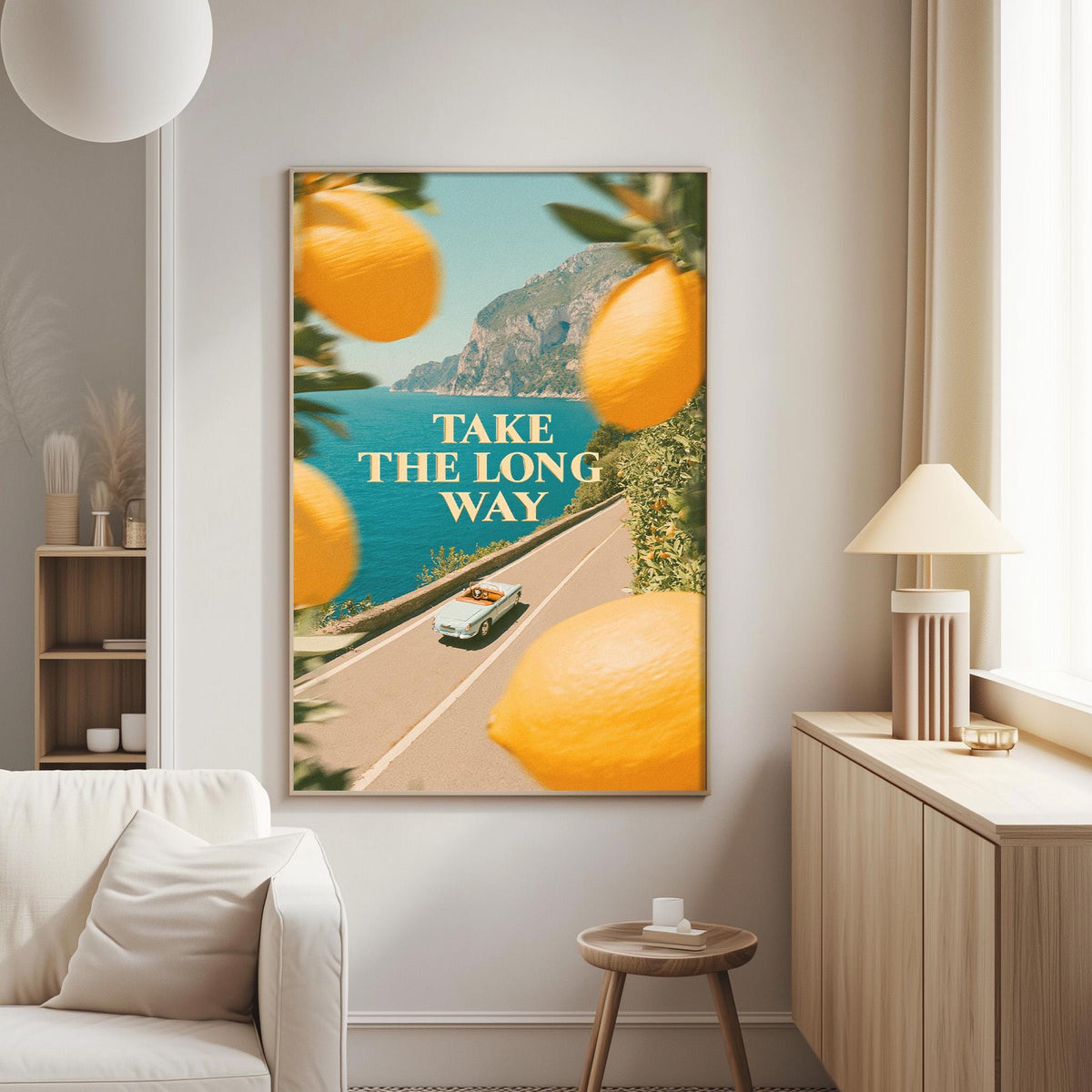 a large framed poster with a scenic road and a car, along with the text "Take the long way" displayed prominently.