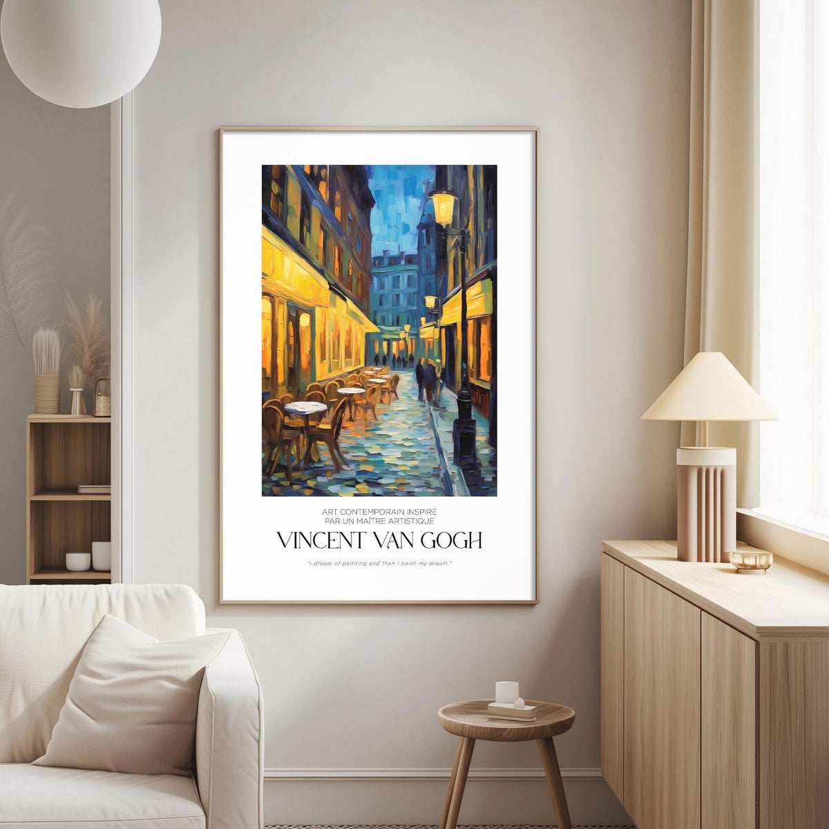 a large painting of a street scene with buildings, tables, and chairs, hanging on a wall in a living room.
