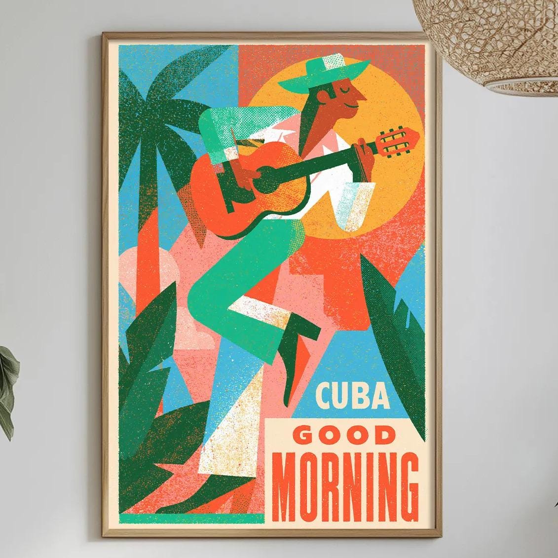 a vibrant poster of a man playing a guitar, surrounded by tropical foliage, hanging on a wall above a dining table with various decorative items and plants.