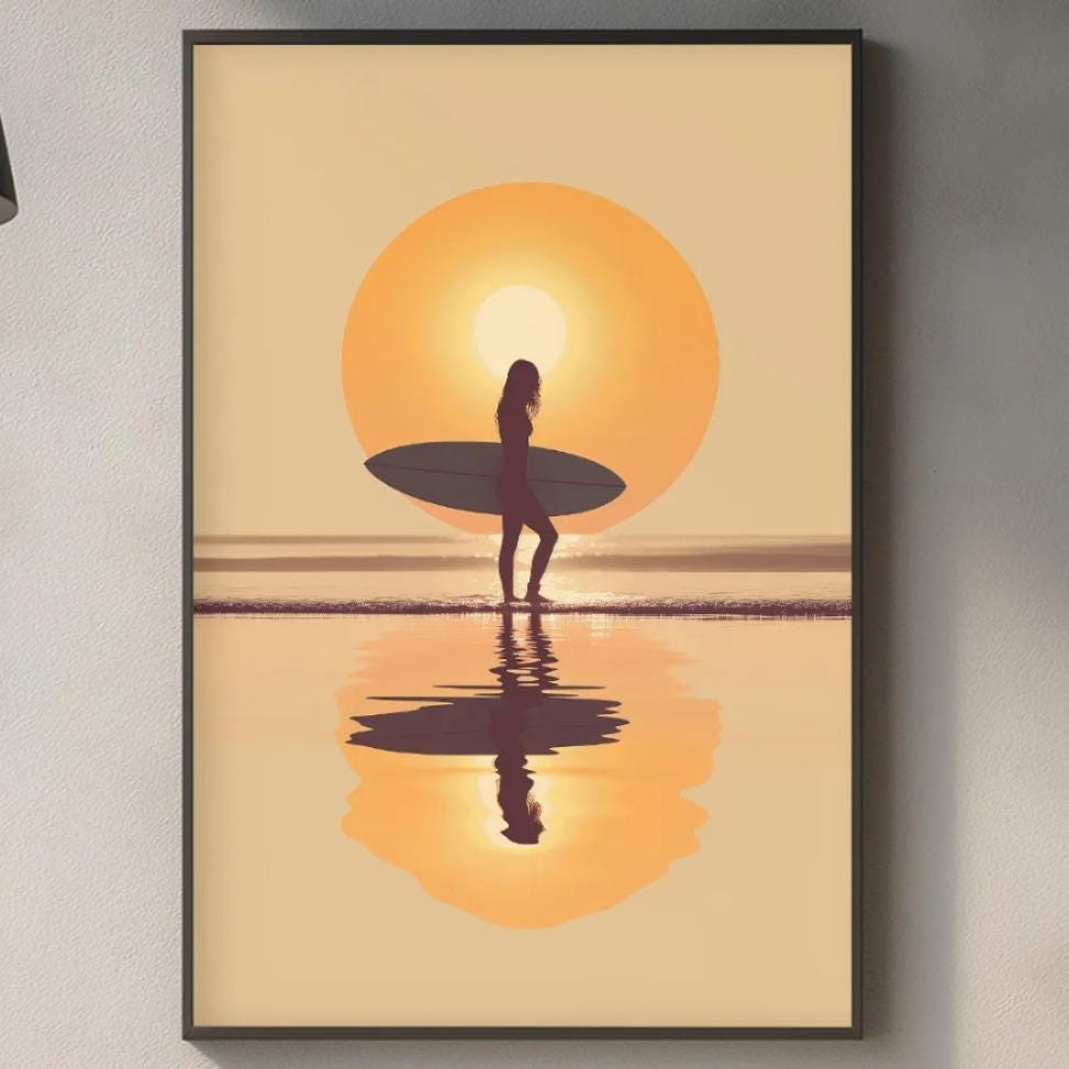 a framed artwork depicting a surfer standing on a beach at sunset, with the sun reflected in the water.