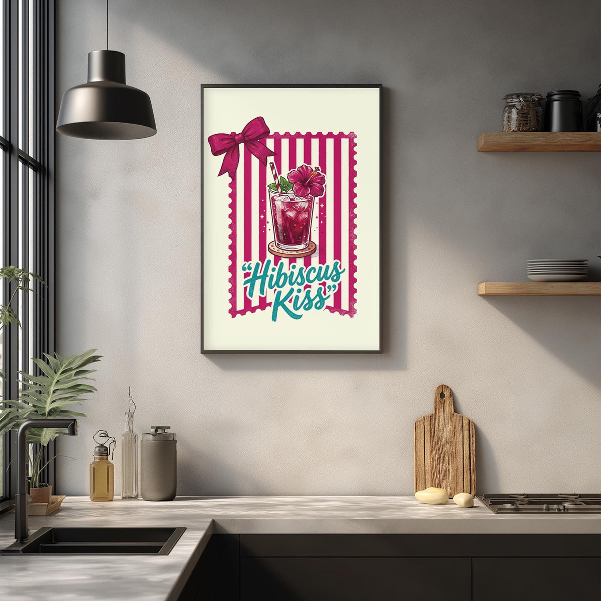 a framed poster with a pink and white striped border, hanging on a wall above a kitchen counter. The poster displays a glass with a pink drink and a pink bow, along with the text "Hibiscus Kiss".