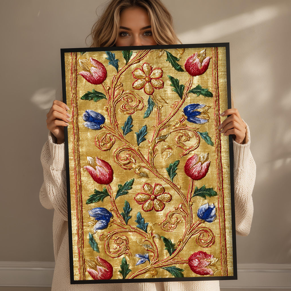 A woman holds up a framed picture with a floral design, featuring red, blue, and green flowers and leaves.