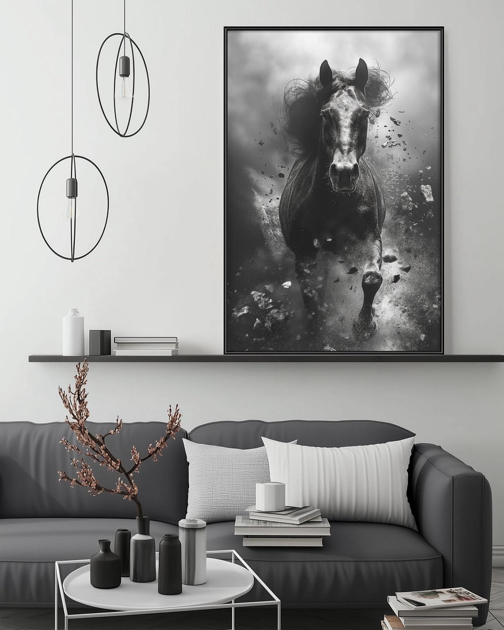a large black and white photograph of a horse running, mounted on a wall above a gray couch with a coffee table in front of it. The room has a minimalist and modern design, with a pendant light fixture hanging above the couch and a shelf displaying decorative items.