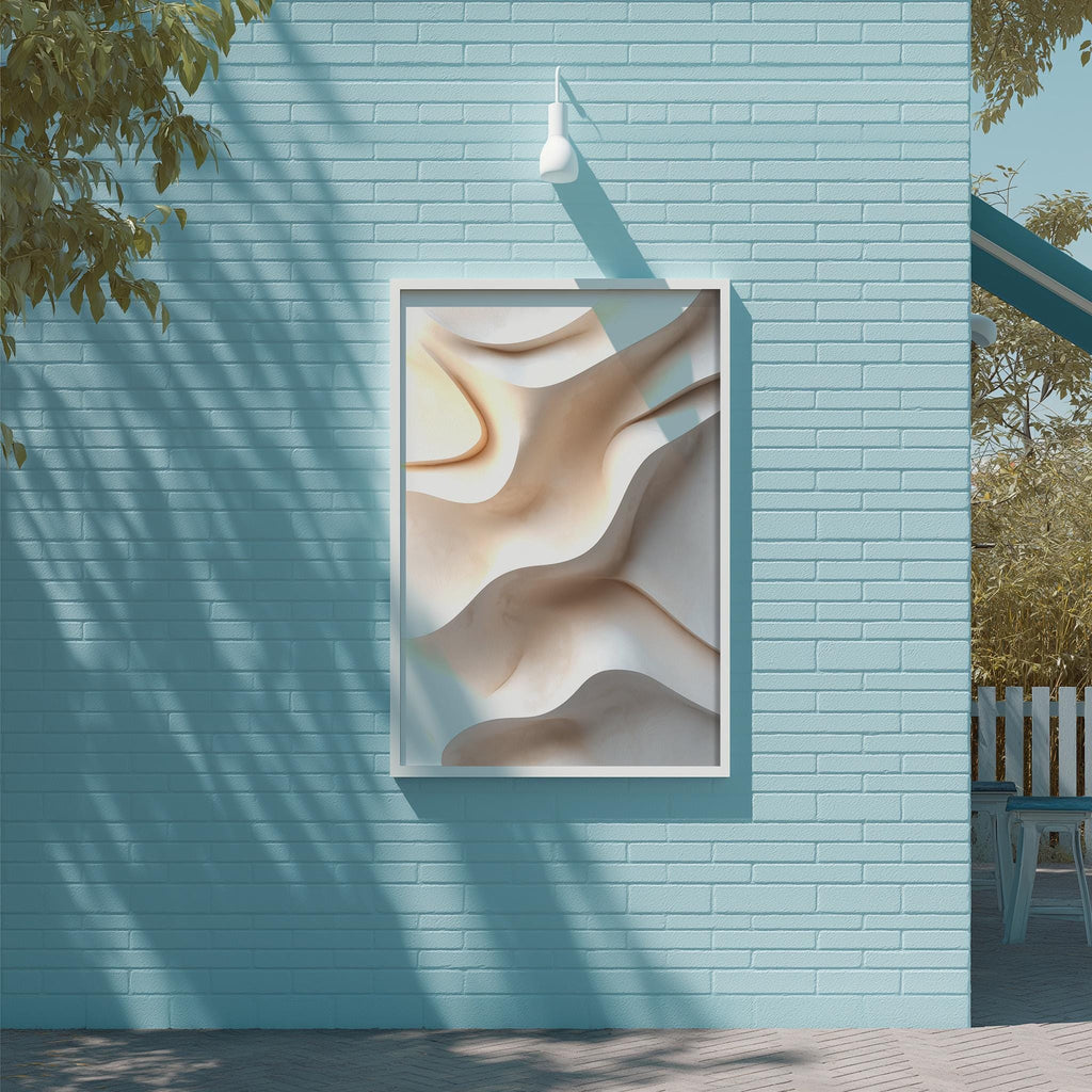 a blue brick wall with a framed abstract artwork hanging on it. The artwork has a wavy, organic design with shades of brown and beige. The wall is situated next to a tree, and there is a white light fixture mounted on the wall above the artwork.