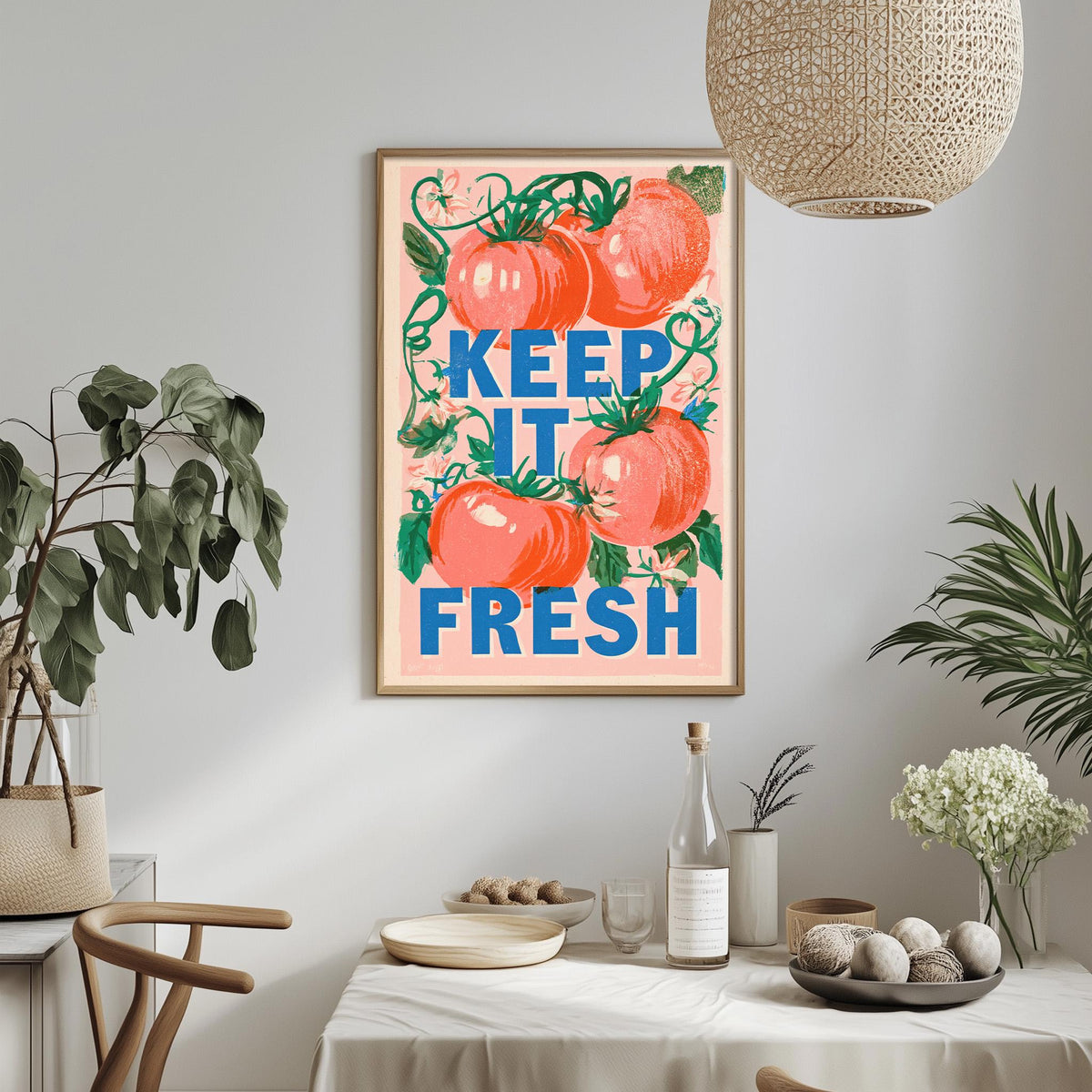 a framed poster with the text "KEEP IT FRESH" hanging on a wall above a dining table with various items on it, including a bottle, a bowl, and a vase.