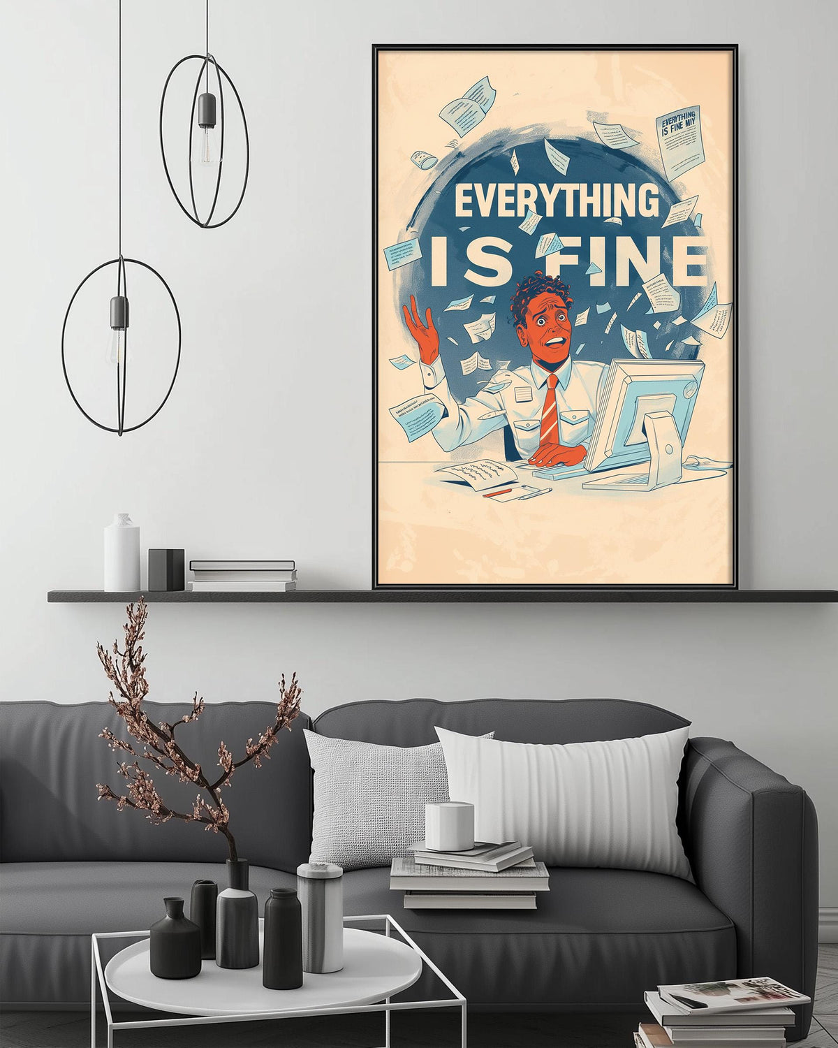 a framed poster with the text "EVERYTHING IS FINE" and an illustration of a person sitting at a desk with a computer. The poster is displayed on a wall above a gray couch in a living room setting.