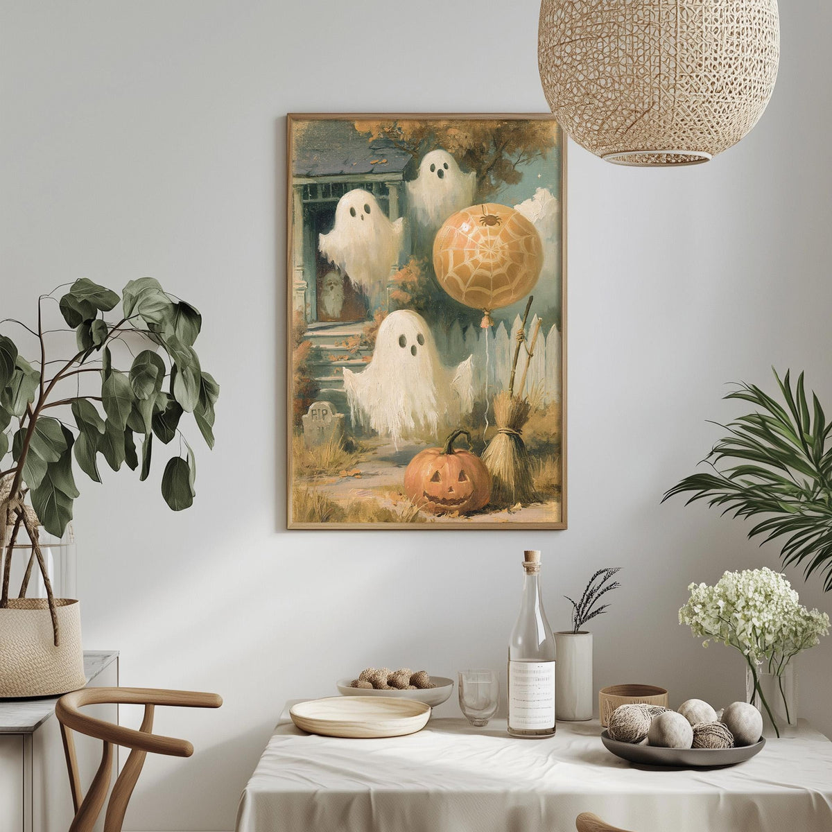 a Halloween-themed painting hanging on a wall, depicting a group of ghostly figures and a jack-o-lantern. The painting is surrounded by various Halloween decorations and elements, such as a potted plant, a bowl of fruit, and a bottle of wine. The overall scene creates a festive and spooky atmosphere, typical of a Halloween celebration.
