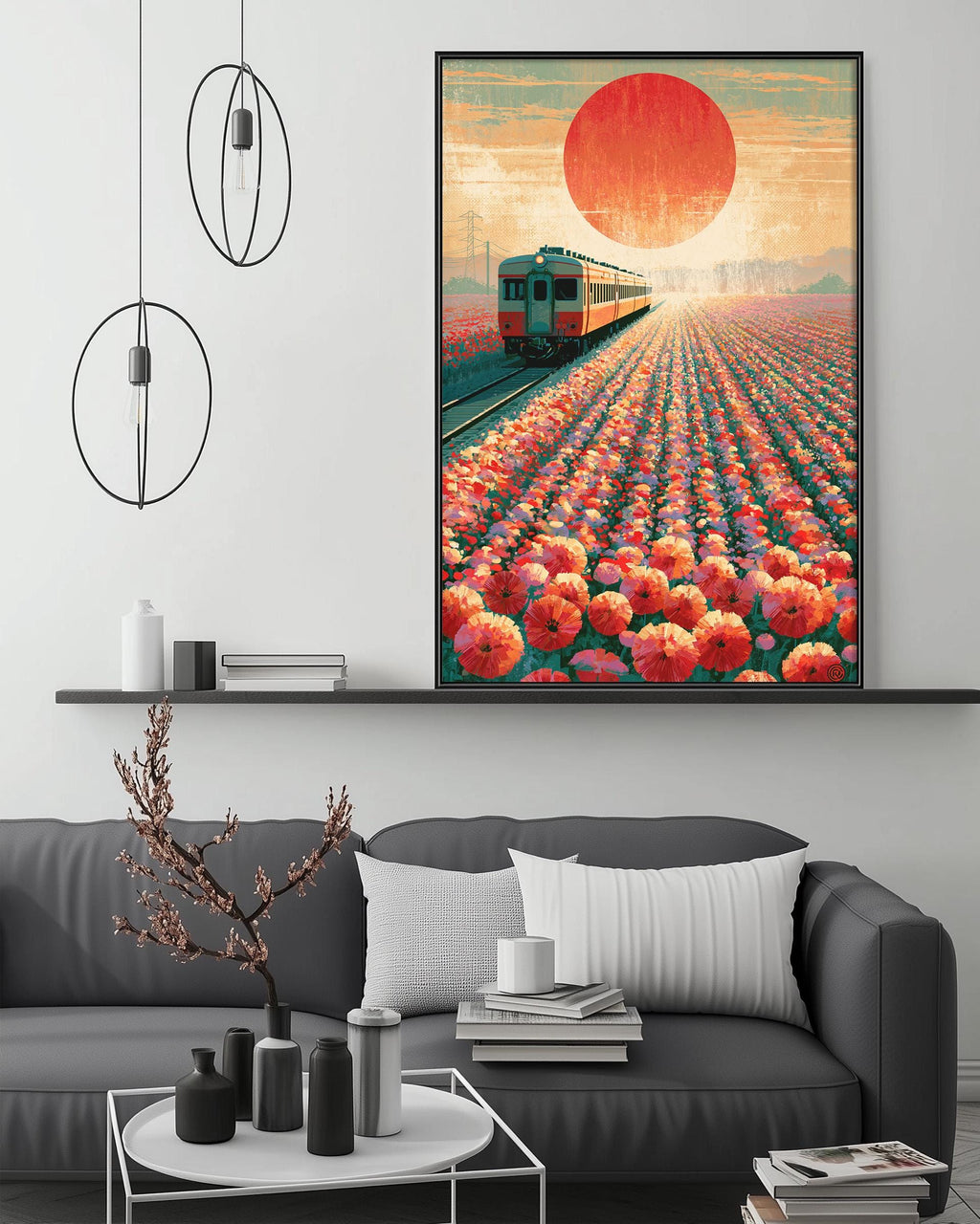 a large framed poster of a train traveling through a field of flowers, with a large sun in the background. The poster is hanging on a wall above a gray couch, which has a coffee table in front of it. The room has a minimalist and modern design, with a few decorative items such as vases and books on the coffee table.