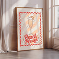 A framed poster with a glass of champagne and the text "Peach Please" on it, placed on a wall near a window.