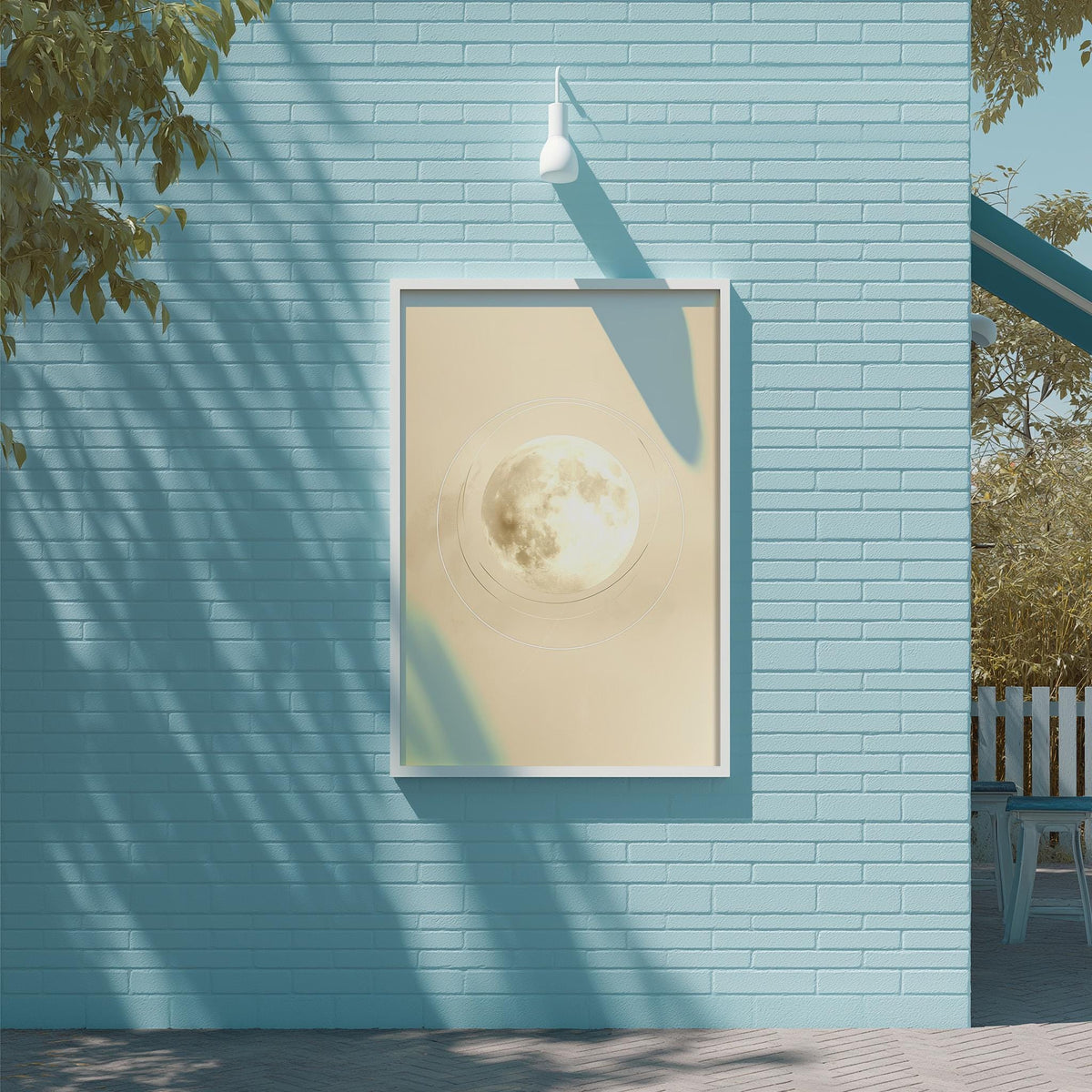 a blue brick wall with a framed picture of a full moon hanging on it.