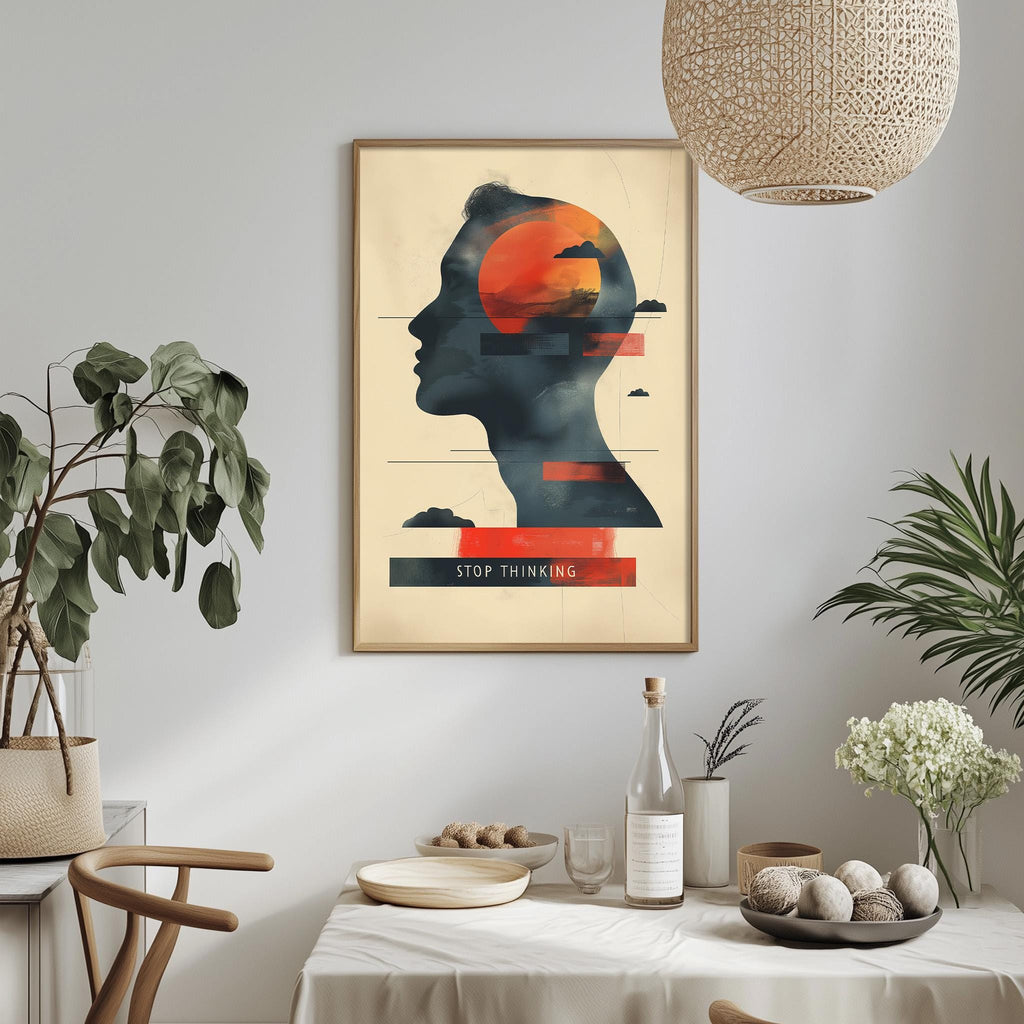 a framed poster with a silhouette of a person's head and the text "STOP THINKING" displayed on it, hanging on a wall above a dining table with various decorative items and plants.