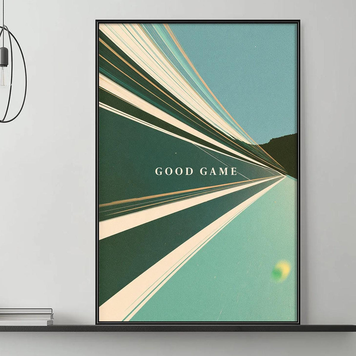 a modern living room with a gray sofa, a coffee table, and a framed poster on the wall. The poster has a green and white abstract design and the text "GOOD GAME" written in white.