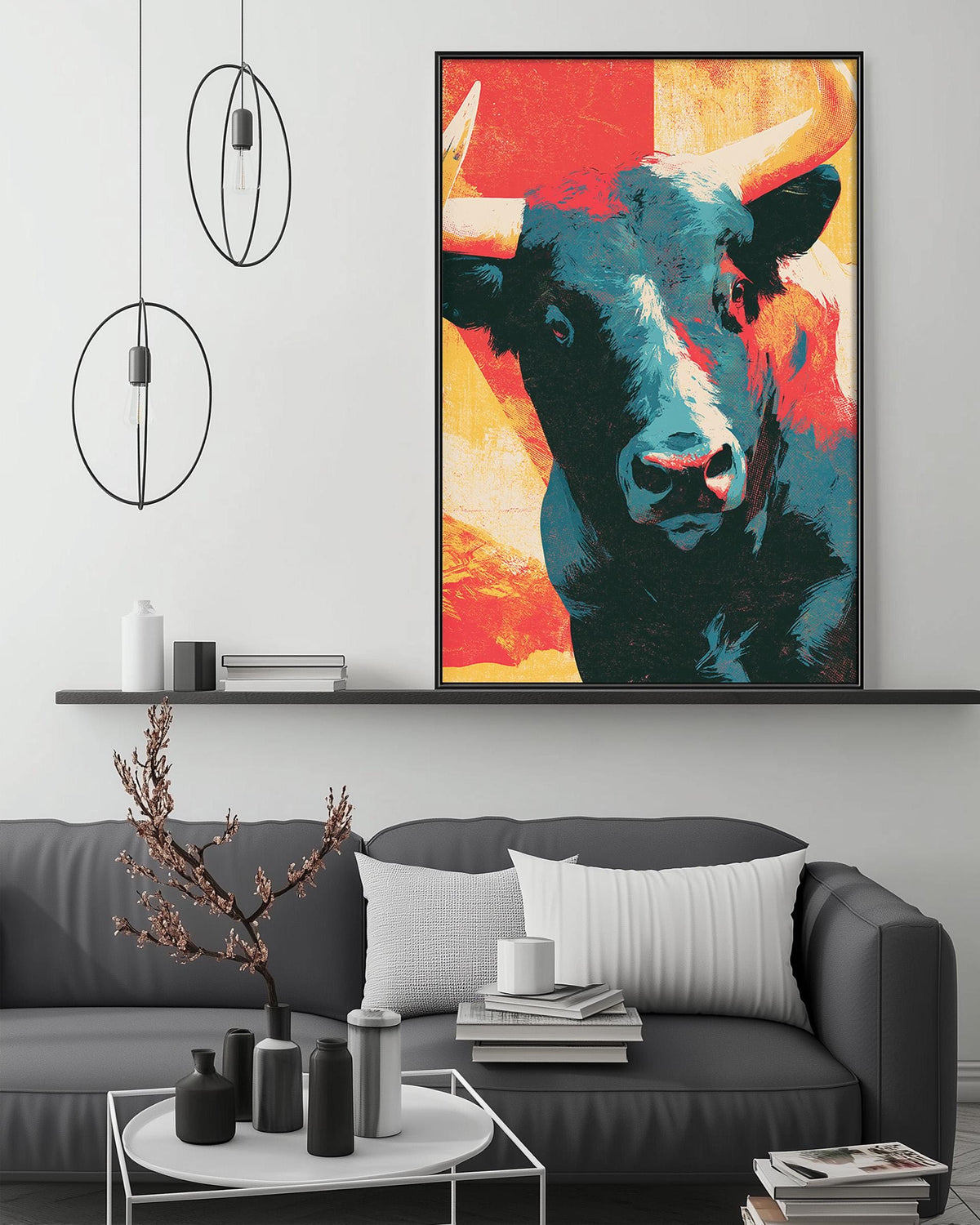 a large, colorful painting of a bull's head hanging on a wall above a gray couch in a living room setting.