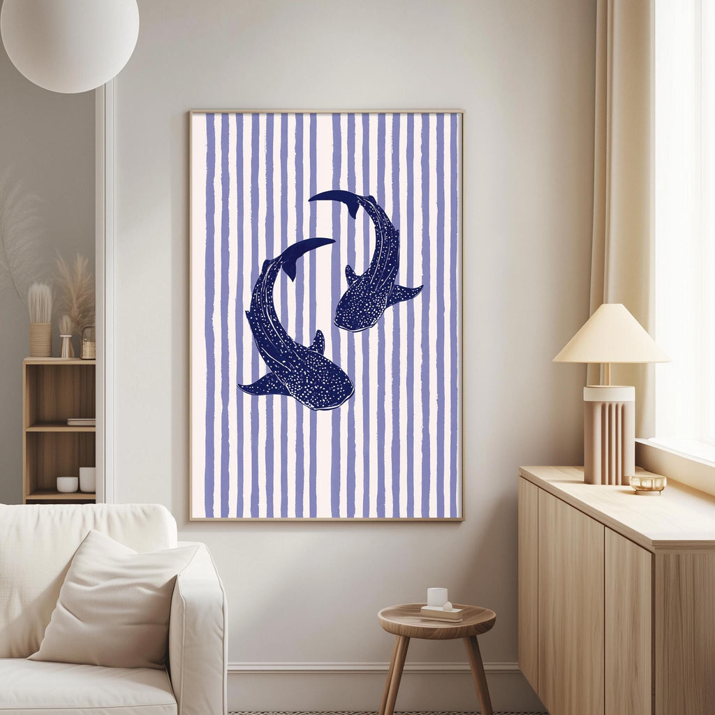 a living room with a white sofa, a wooden side table, and a framed artwork of two blue sharks swimming against a striped background.