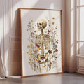 a framed illustration of a skeleton surrounded by a variety of flowers and plants.