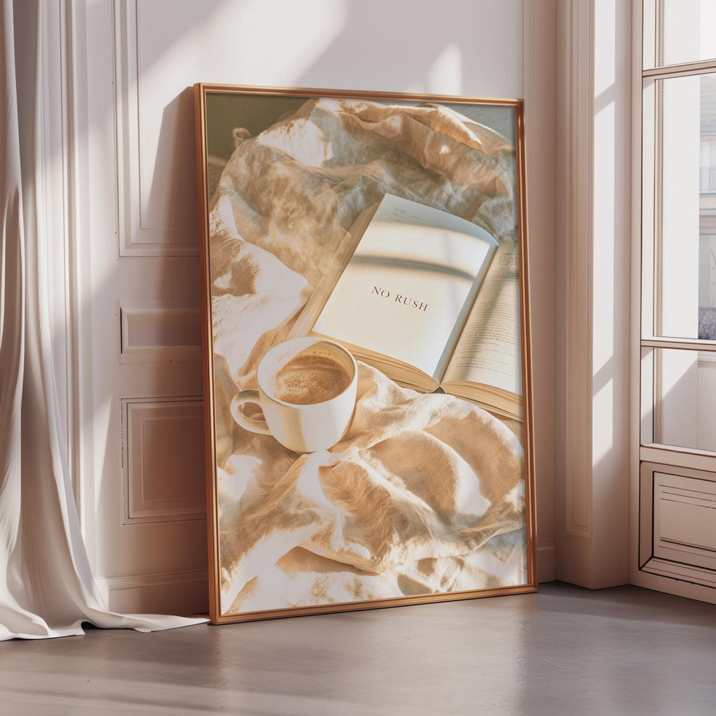 A framed image depicting a book titled "No Rush" resting on a beige blanket, with a cup of coffee placed next to it.