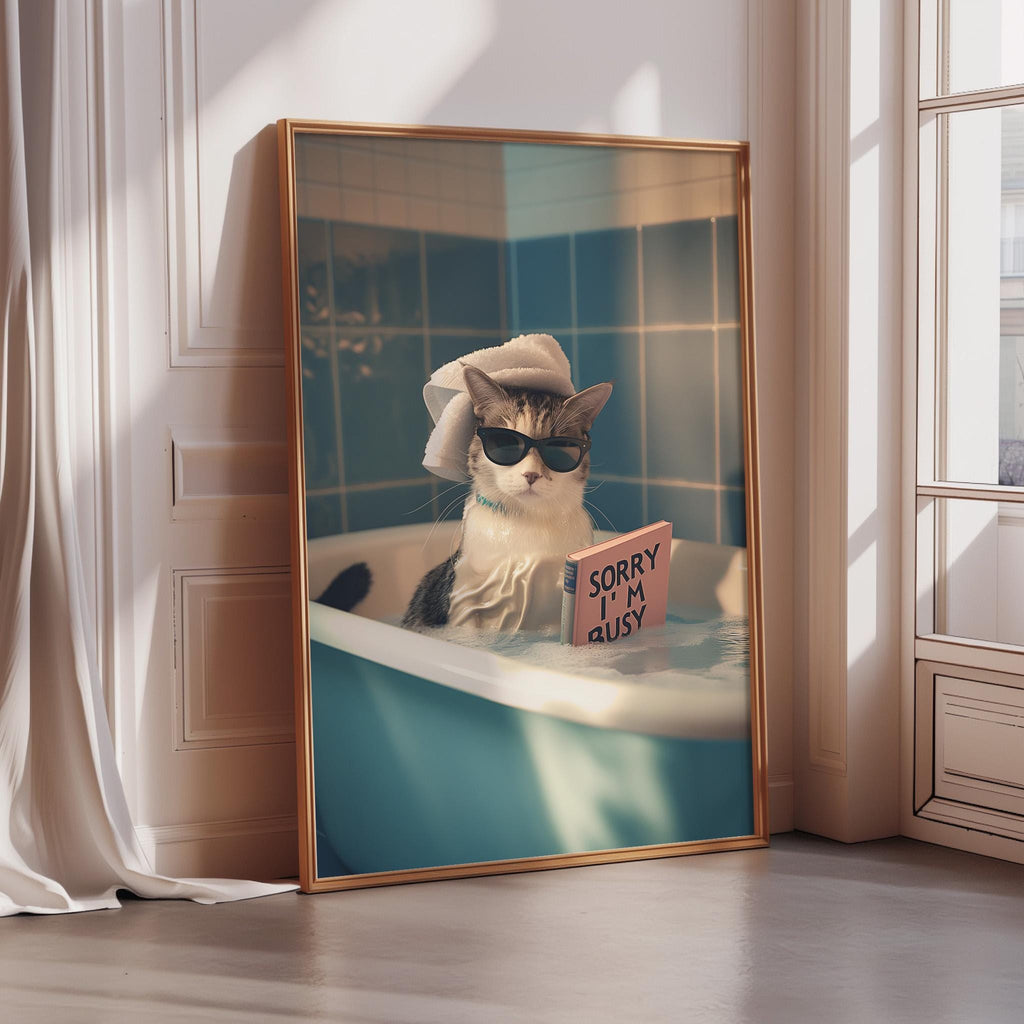 A cat wearing sunglasses and a towel around its neck is sitting in a bathtub, with a sign that says "Sorry I'm Busy" in front of it.