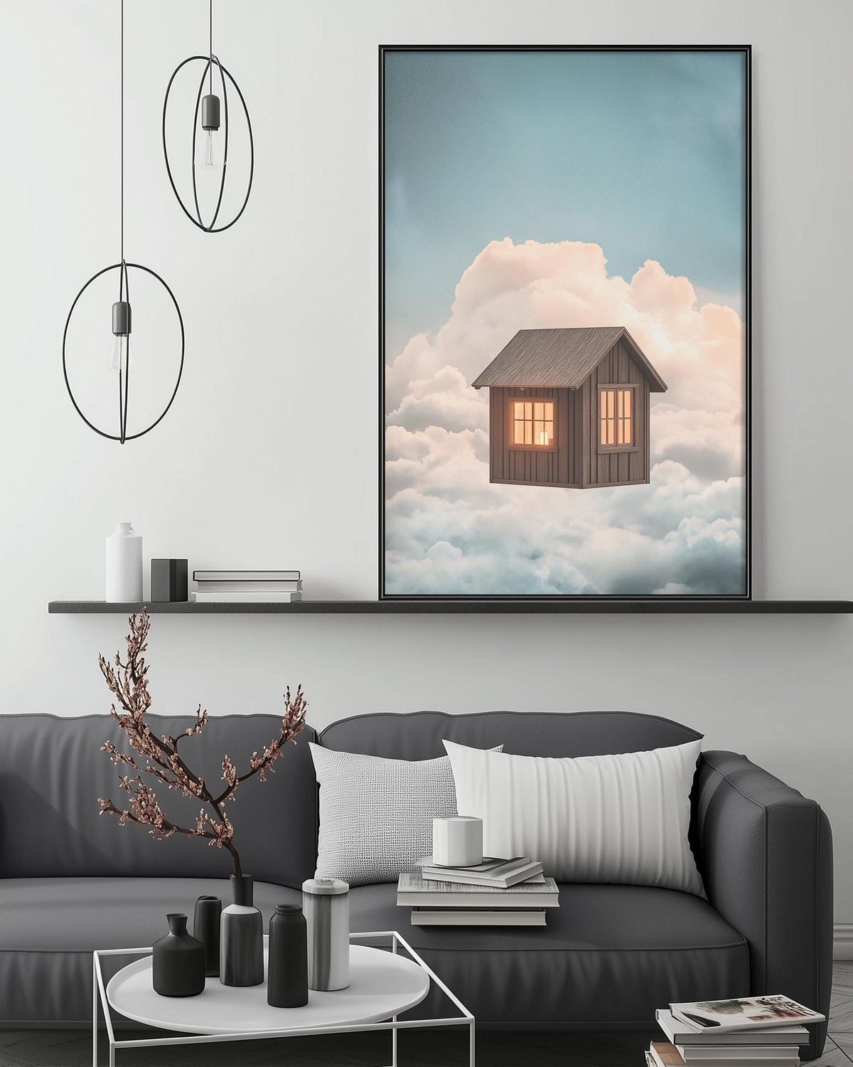 a cozy living room with a gray sofa, a coffee table, and a large framed picture of a house floating in the clouds above it.