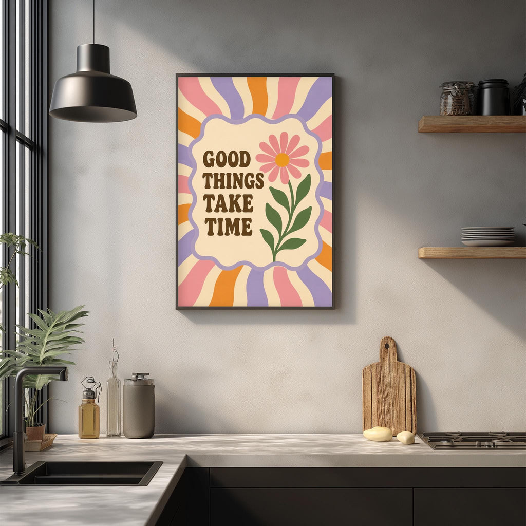 a kitchen counter with a framed poster hanging on the wall above it. The poster has a colorful design with a flower and the text "GOOD THINGS TAKE TIME" written on it.