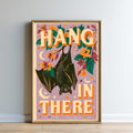 The image is a framed poster with a bat illustration and the text "HANG IN THERE" written in large letters.