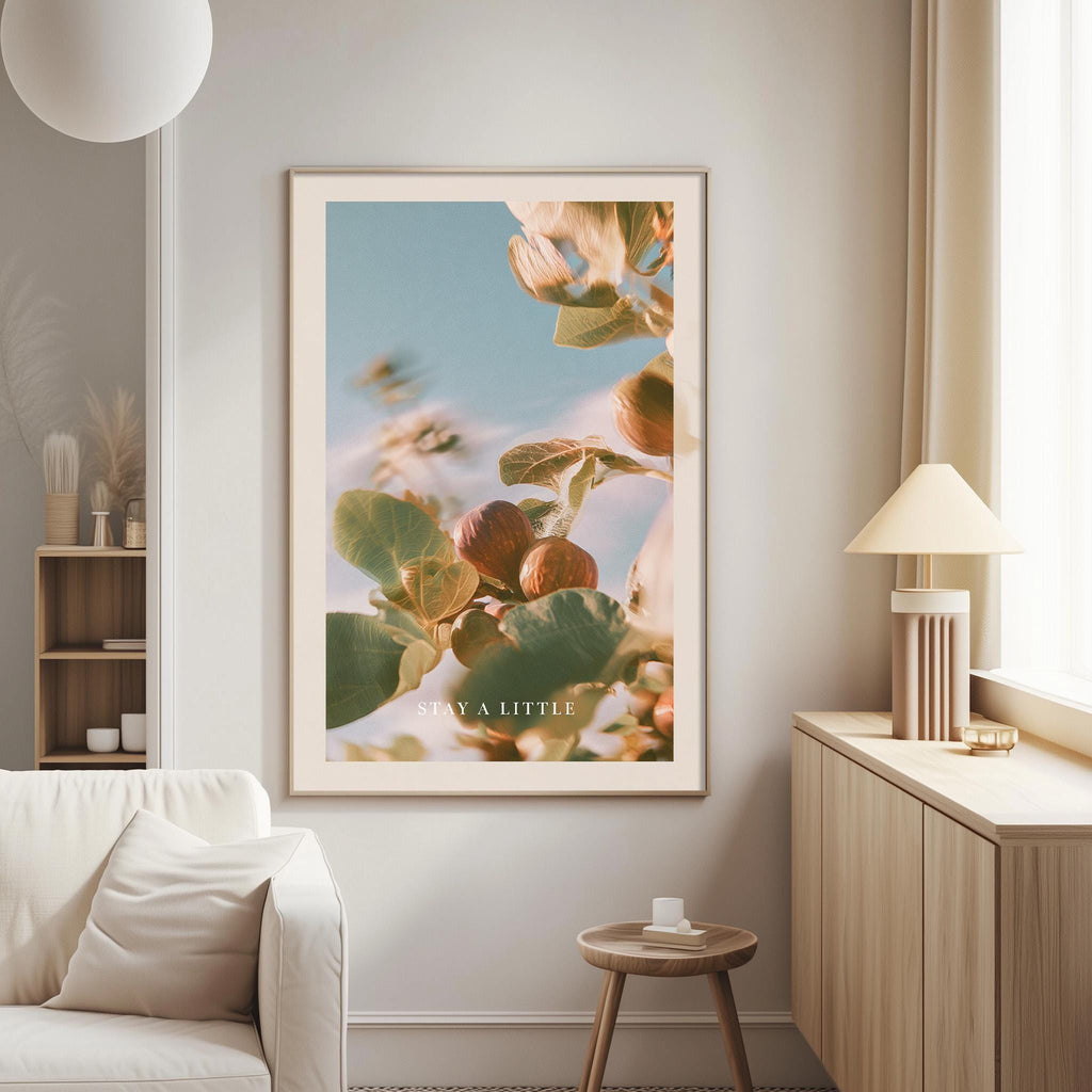 a large framed poster of a plant with a blue sky and green leaves, hanging on a wall in a living room.