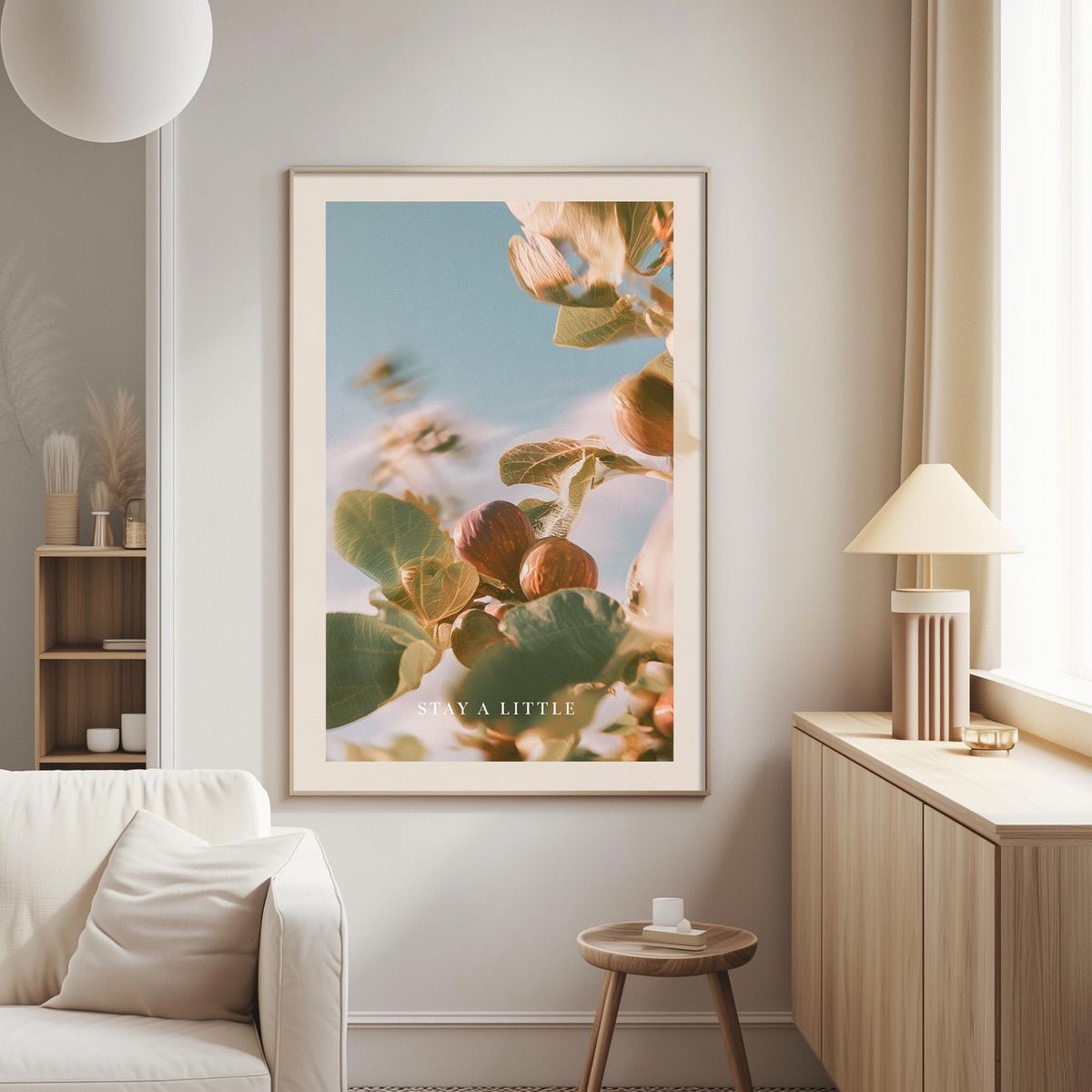 a large framed poster of a plant with a blue sky and green leaves, hanging on a wall in a living room.