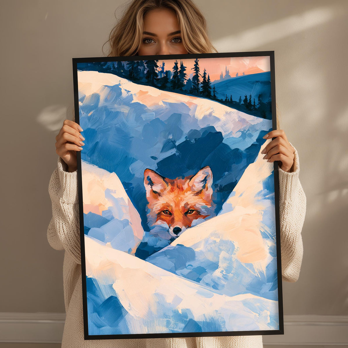 A woman holds up a framed painting depicting a fox peeking out from a snowy landscape.