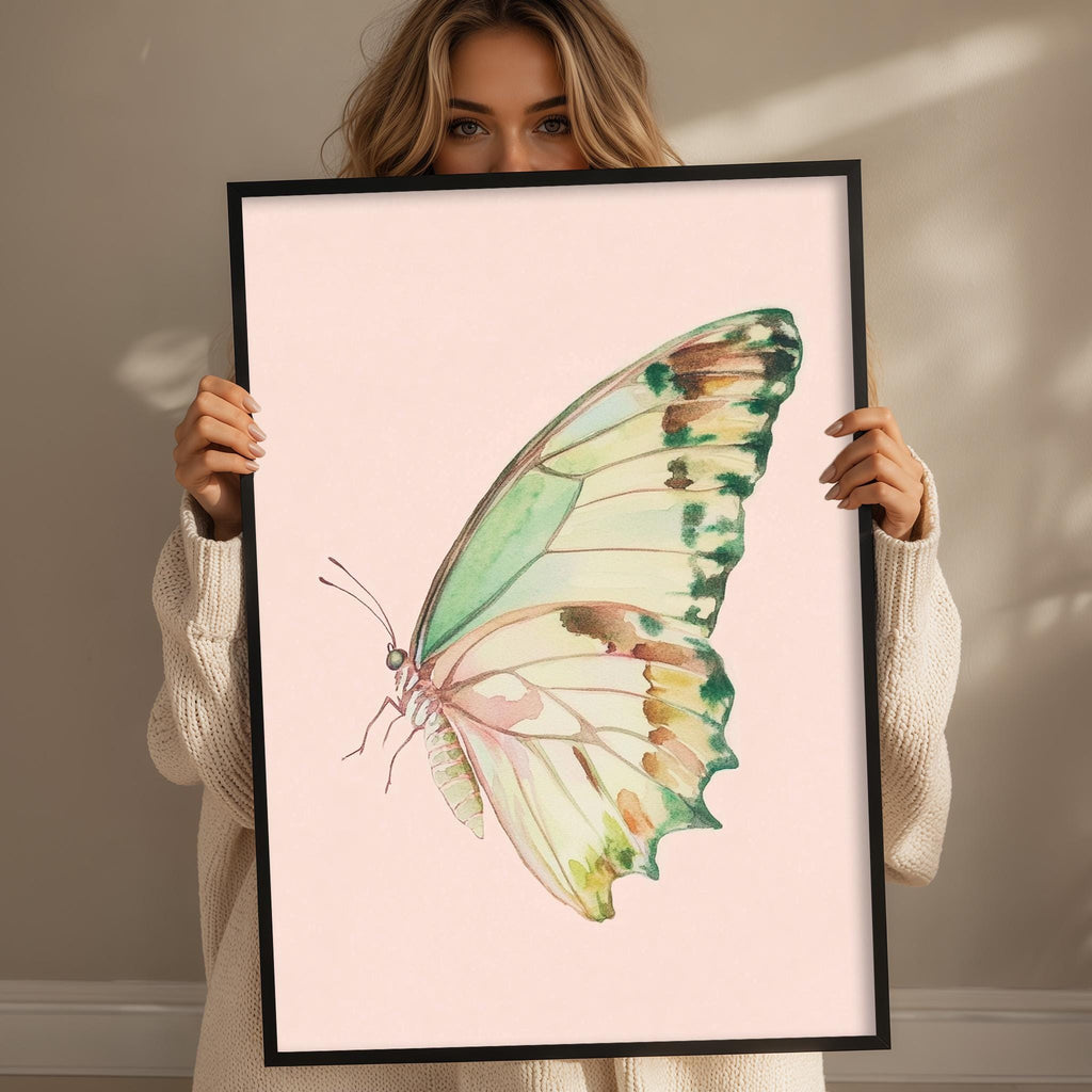 A woman is holding up a framed picture of a colorful butterfly.