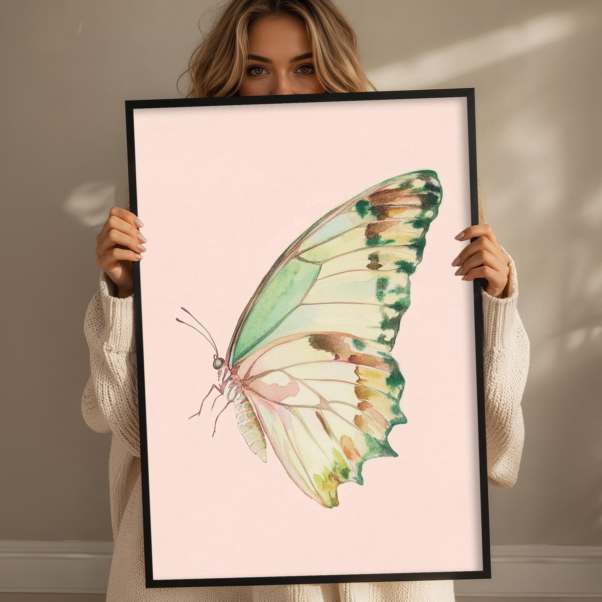 A woman is holding up a framed picture of a colorful butterfly.
